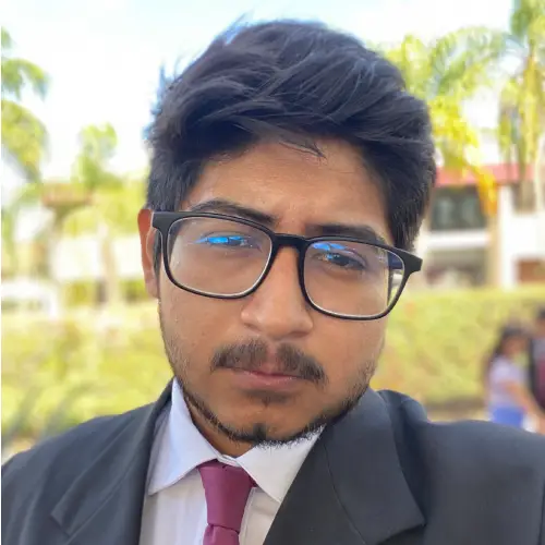 Retrato de Mauricio, con saco, camisa y corbata, al aire libre.